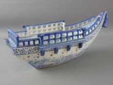 A CHINESE PORCELAIN BOAT, blue and white decorated with swirling waves and birds to the keel,