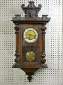 A CIRCA 1900 VIENNA STYLE WALL CLOCK with shaped mask decorated top above a single glazed door