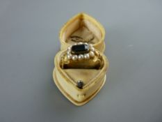 A PINCHBECK RING having a centre oblong emerald beryl stone and surrounding seed pearls, 3.5 grms