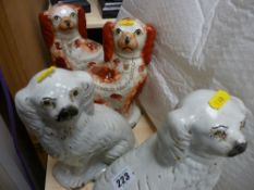 Pair of white Staffs pottery seated dogs and a pair of red and white Staffs pottery seated dogs