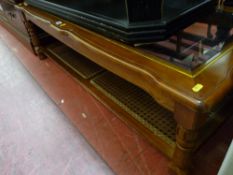 Reproduction walnut coffee table with bevelled glass top and cane work undershelf