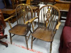 A pair of wooden wheel back elbow chairs