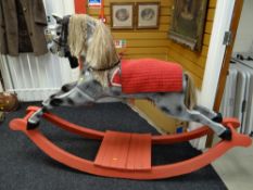A painted wooden rocking horse with glass eyes, leather reins & saddle etc
