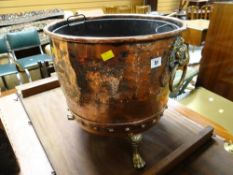 An antique copper log bin with three brass claw feet & brass lion head ring handles together with