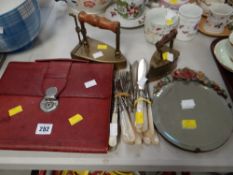 A barbola easel mirror, a pair of antique flat irons, quantity of loose cutlery & a folding