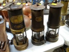 Three antique mining lamps with labels
