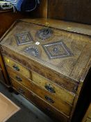 An antique carved oak sloped bureau with two long & two short drawers (for restoration)