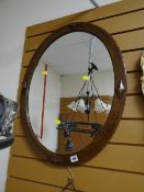 A wooden framed oval bevelled wall mirror