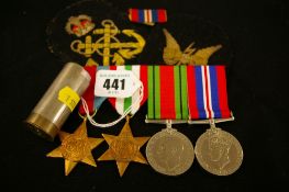 World War II group of four service medals (unmarked), two service arm badges and a spring coin