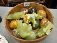 Carved treen bowl with quantity of onyx and similar eggs and figures