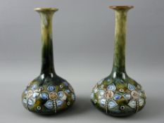 A PAIR OF ROYAL DOULTON STONEWARE BOTTLE VASES having slender necks and stylized floral decoration
