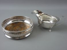 A SILVER WINE BOTTLE COASTER with mahogany base, London 1967 and a gravy boat, Birmingham 1970, 3.
