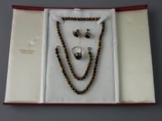A TIGER'S EYE TRIO OF NECKLACE, 58 cms long, silver signet ring with cabochon tiger's eye and a pair