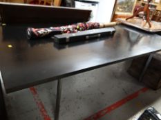 A large black retro dining table on chrome legs
