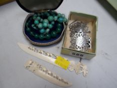 Two foliate engraved pierce-work silver buckles, two carved paper knives & two strands of beads (be