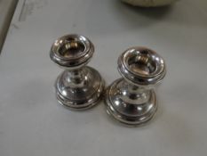 A pair of silver circular based candlestick holders