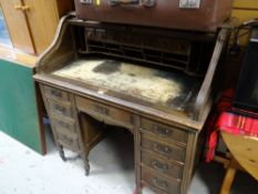 A vintage roll top desk with tambour cover and fitted interior