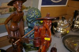 Two Oriental carved male figures and a porcelain Temple Dog figure