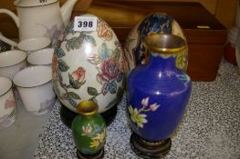 Two decorative porcelain eggs on stands and modern cloisonne