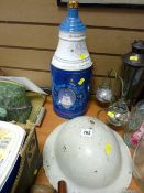 ARP style helmet and a Bell's Scotch Whisky tinned bottle commemorating the Queen Mother's 90th