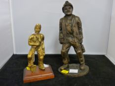 Brass miner figurine on a wooden stand and another resin made