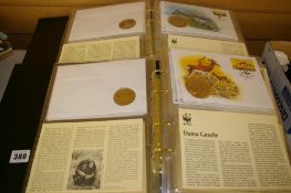 Two albums containing WWF - World Wildlife Fund commemorative coins, stamps and cards within two