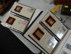 Two folders of gold plated stamp replicas