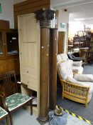 A pair of decorative wooden columns with acanthus leaf decoration to the top