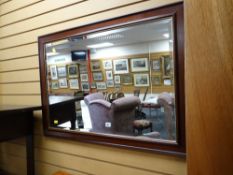 A wooden framed bevelled wall mirror