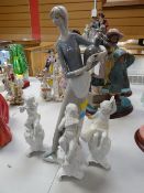 A Lladro porcelain figure of a lady carrying a water vessel together with three cherubic glazed