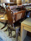 A dark wood nest of three tall tables together with a magazine rack