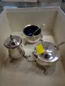 A three-piece Birmingham silver condiment set, each element raised on three lion head & claw feet