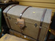Vintage canvas dome top travel trunk with wooden banding together with an internal shelf
