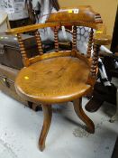 A vintage light oak with carved decoration & spindle supports drum-style office / captain's chair
