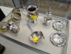 A parcel of silver tableware including tea strainer, mustard pot, cream jug, pepperette, five napkin