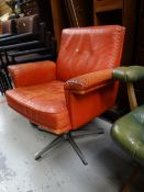 A retro stitched red leather swivel armchair on chrome tripod support
