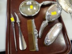 A six-piece silver backed dressing table set with relief decoration