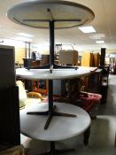 Three modern metal legged circular cafe / restaurant-style tables