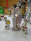A Continental porcelain model of a sculptor (damage) together with a pair of cherubic figures