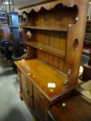 A compact vintage polished wood dresser, a two-shelf rack with a two-cupboard base