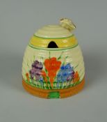 A CLARICE CLIFF POTTERY BEEHIVE HONEY POT with floral decoration & insect handle, 9cms high