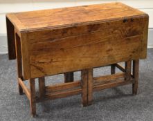A NINETEENTH CENTURY JOINED OAK GATE LEG TABLE, the base with twin 'gates' at either side