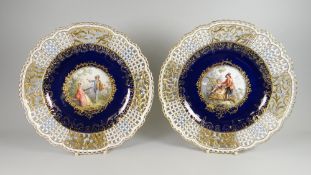A PAIR OF MEISSEN RIBBON PLATES centred with a hand decorated Watteau-style vignette of courtiers in