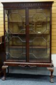 A GOOD TURN OF THE CENTURY STANDING CABINET with two astragal glazed doors having a carved and