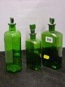 Three green glass medicine or similar bottles with stoppers