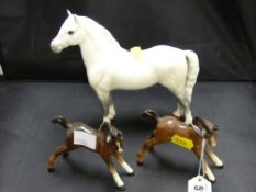 Two Beswick pottery foals and a Beswick pottery dappled grey horse