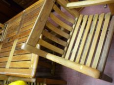 Large teak garden table with parasol and a set of six bench style armchairs