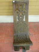 A SURINAME TRIBAL FOLDING CHAIR fashioned from a single piece of timber with pierced and carved