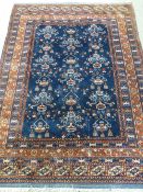 A MULTI BORDERED BLUE & RED GROUND EASTERN WOVEN CARPET having a repeating floral and lantern