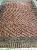 A GOOD LARGE EASTERN WOOLLEN WOVEN CARPET, red ground multi-bordered with a repeating segmented
